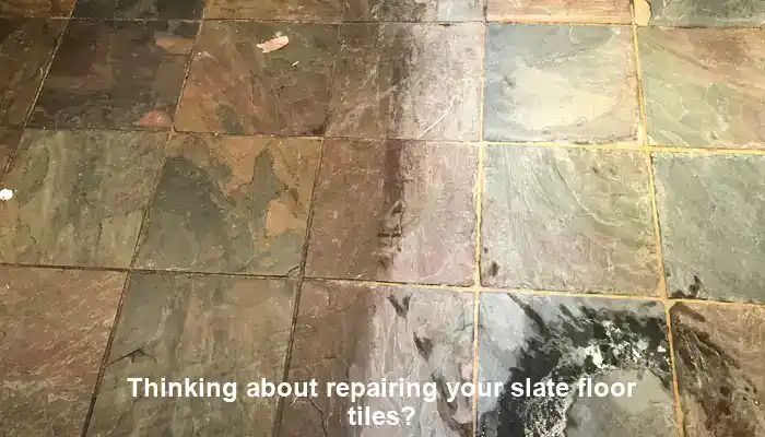 Cracked slate floor tiles with worn patches requiring repair suitability evaluation