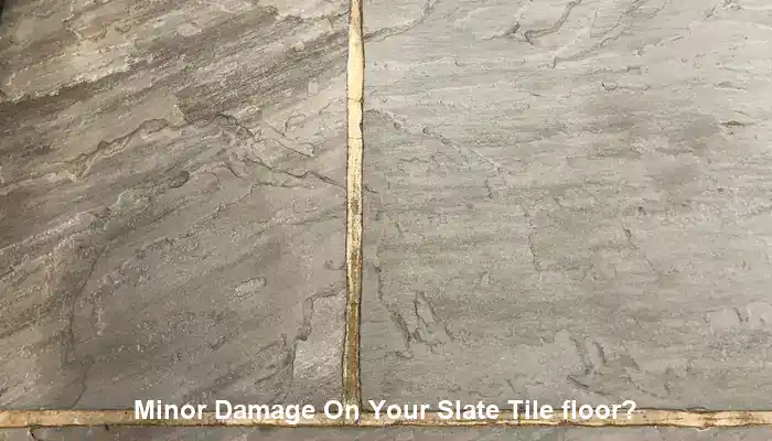 Localized slate floor damage beside stable surrounding tiles needing repair evaluation